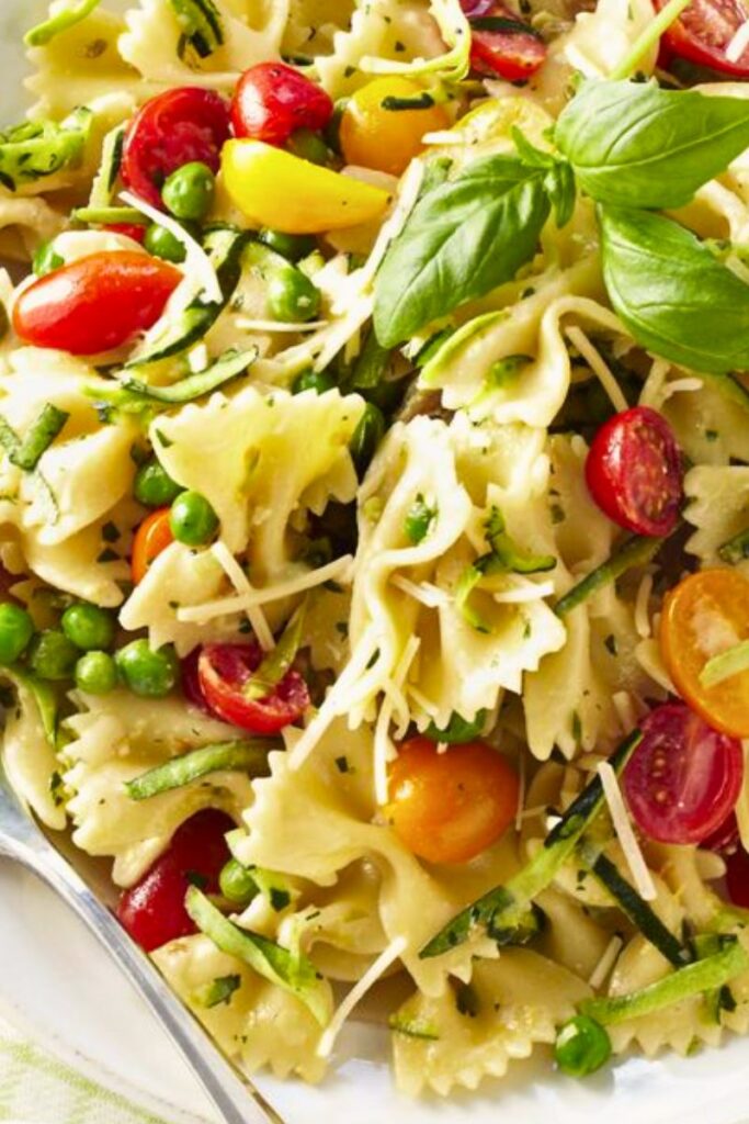 Pesto Pasta Salad with fresh basil, cherry tomatoes, and mozzarella in a light, herby dressing
